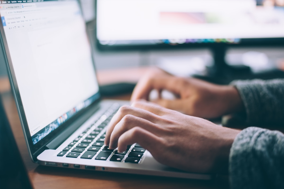Person searching digital files on a laptop in an office.